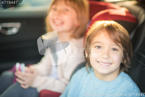 Image of kids  sitting together in modern car