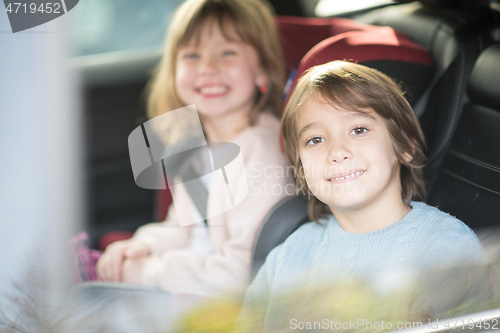 Image of kids  sitting together in modern car