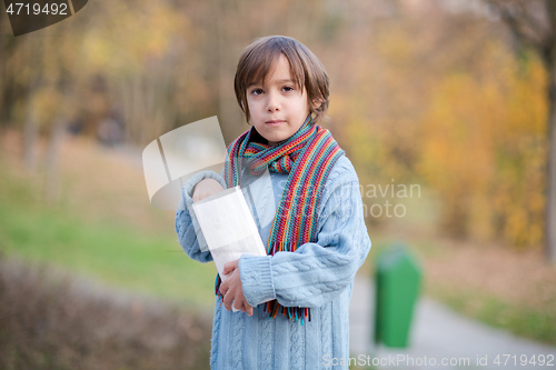 Image of cute little boy in park eating popcorn