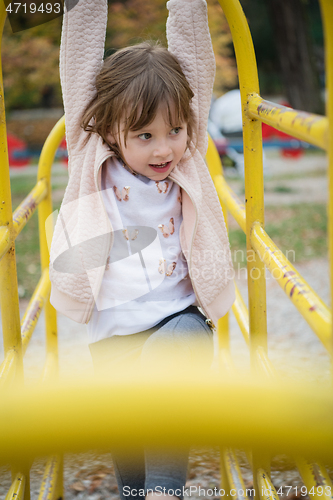 Image of cute little girl  having fun in playground