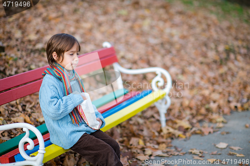 Image of cute little boy in park eating popcorn