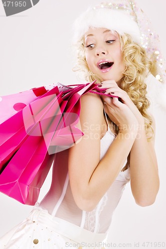 Image of cheerful santa helper girl with shopping bags