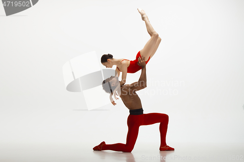 Image of Young graceful couple of ballet dancers dancing on white studio background