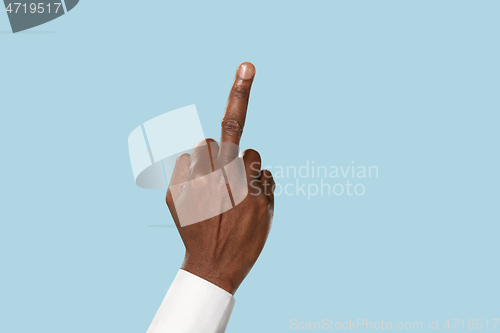 Image of Male hand demonstrating a gesture of fuck isolated on blue background