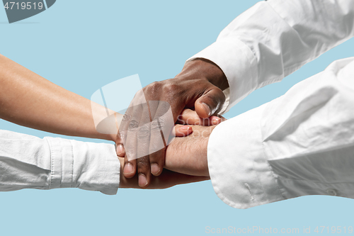 Image of Male and female hands holding isolated on blue studio background