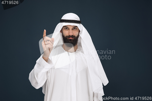 Image of Arabian saudi businessman on dark blue studio background