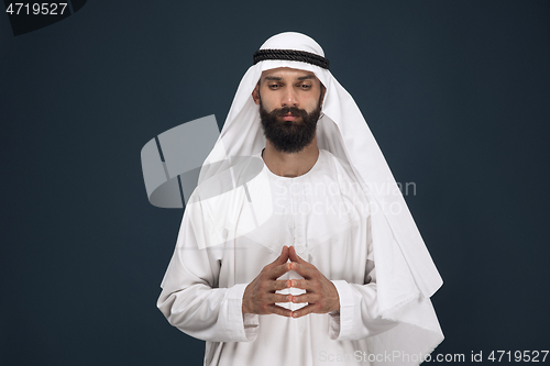 Image of Arabian saudi businessman on dark blue studio background