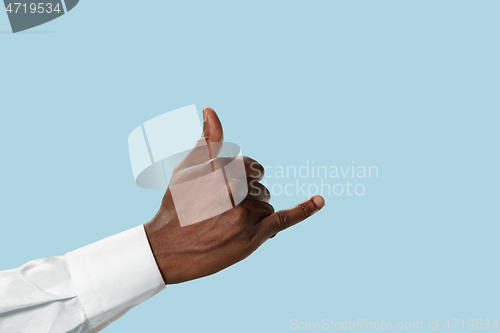 Image of Male hand demonstrating a gesture CALL ME isolated on blue background