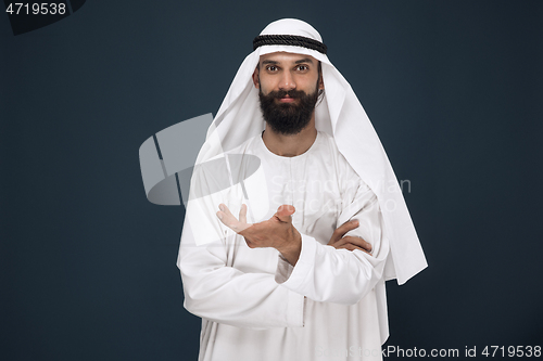 Image of Arabian saudi businessman on dark blue studio background