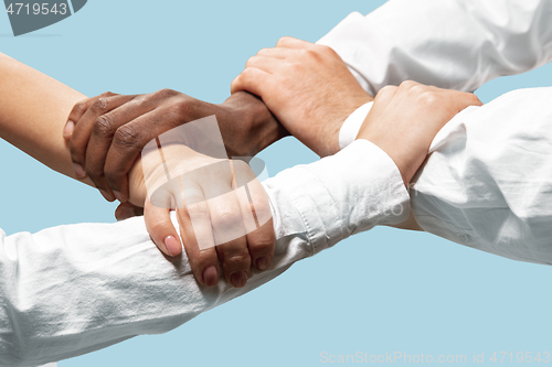 Image of Male and female hands holding isolated on blue studio background