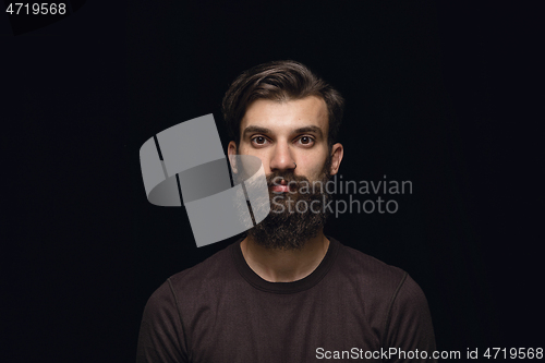 Image of Close up portrait of young man isolated on black studio background