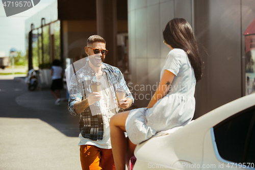 Image of Young couple preparing for vacation trip on the car in sunny day