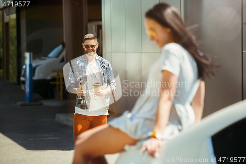 Image of Young couple preparing for vacation trip on the car in sunny day