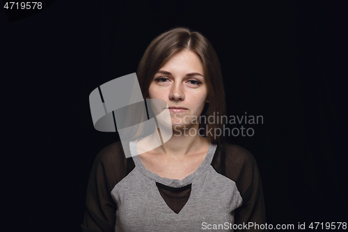 Image of Close up portrait of young woman isolated on black studio background