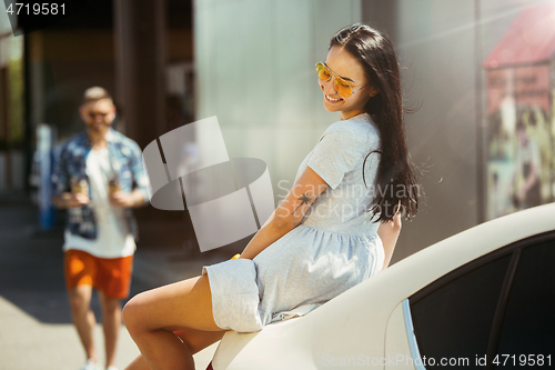 Image of Young couple preparing for vacation trip on the car in sunny day