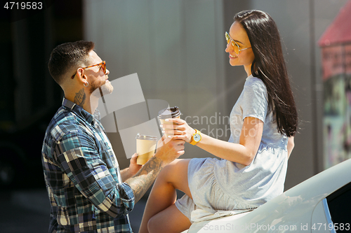 Image of Young couple preparing for vacation trip on the car in sunny day