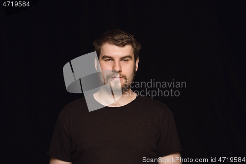 Image of Close up portrait of young man isolated on black studio background