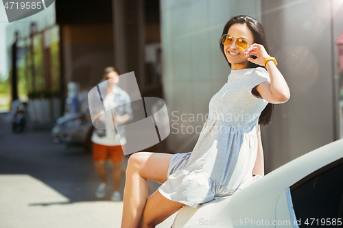 Image of Young couple preparing for vacation trip on the car in sunny day