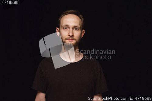 Image of Close up portrait of young man isolated on black studio background