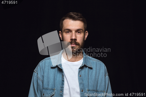 Image of Close up portrait of young man isolated on black studio background