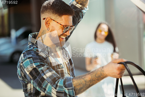 Image of Young couple preparing for vacation trip on the car in sunny day