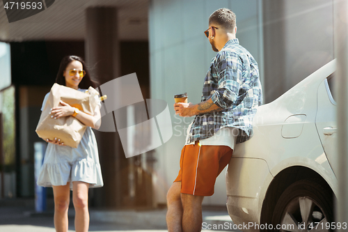 Image of Young couple preparing for vacation trip on the car in sunny day