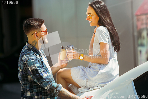 Image of Young couple preparing for vacation trip on the car in sunny day