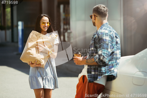 Image of Young couple preparing for vacation trip on the car in sunny day