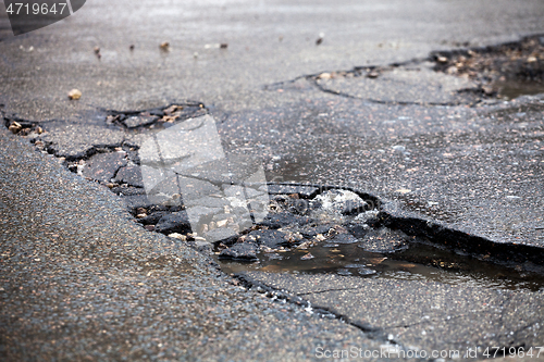 Image of Broken pavement and pothole asphalt road after winter.
