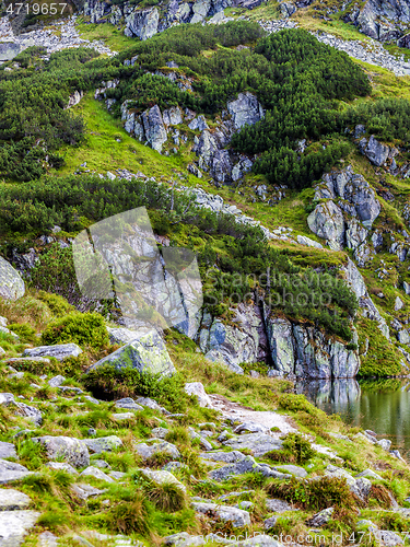 Image of Mountain slope with small lake at botom