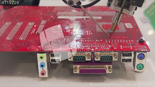 Image of Automated robotic equipment repairing motherboard