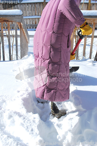 Image of Female shoveling snow.