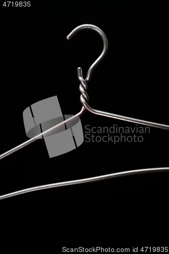 Image of simple metal hanger on a black 