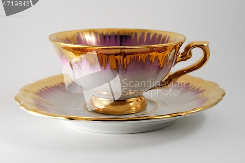 Image of empty porcelain tea cup with gilding on a white backdrop