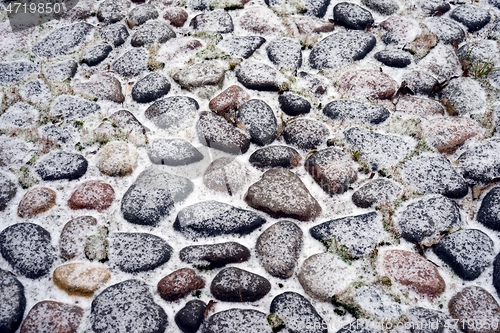 Image of antique cobblestone pavement covered with snow