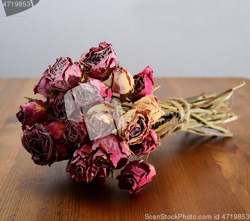 Image of bouquet of dried roses on a wooden table