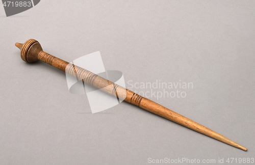 Image of vintage wooden spindle on gray background