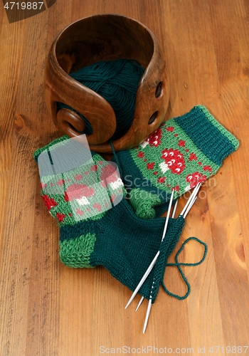 Image of a woolen socks with amanita and wool in a wooden bowl 