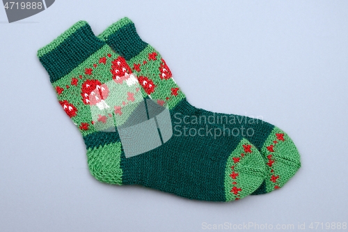 Image of a woolen socks with amanita on neutral background 