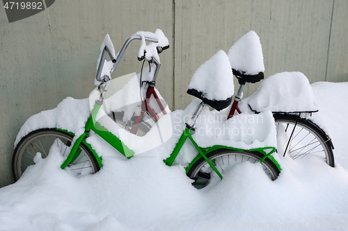 Image of two snow covered bikes in winter
