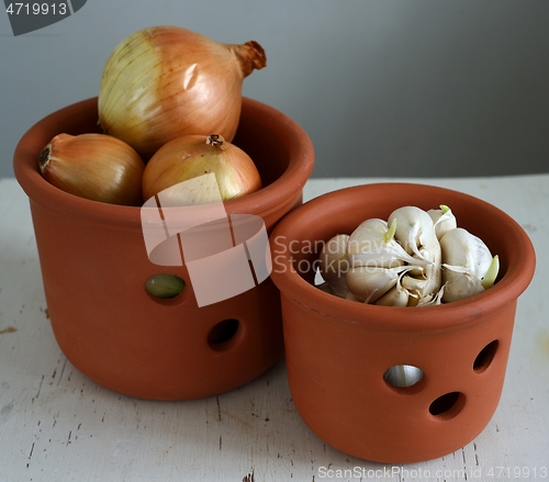 Image of onions and garlic in ceramic pots