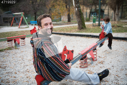 Image of father and  child having fun together  in park