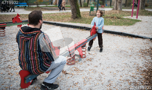 Image of father and  child having fun together  in park