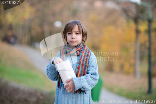 Image of cute little boy in park eating popcorn