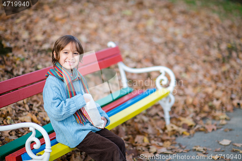 Image of cute little boy in park eating popcorn