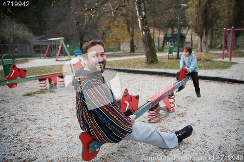 Image of father and  child having fun together  in park