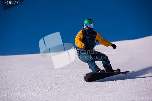 Image of snowboarder running down the slope and ride free style