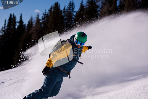 Image of snowboarder running down the slope and ride free style