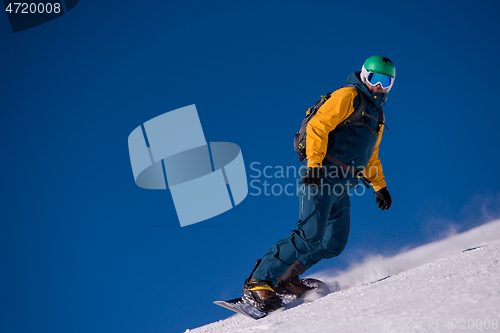 Image of snowboarder running down the slope and ride free style