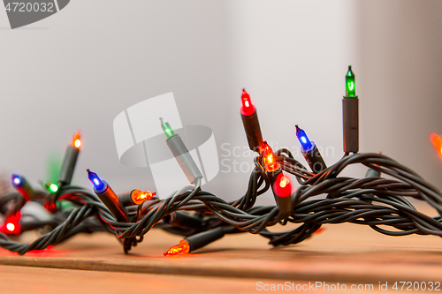 Image of christmas garland lights on wooden background